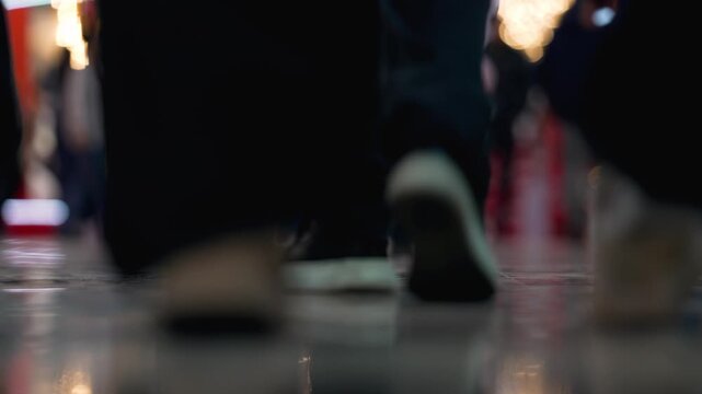 Crowd people walking street legs in shoes. City urban background. Footsteps echo on the pavement as people walk through a busy area filled with shops and lights. The crowd moves steadily, creating a l