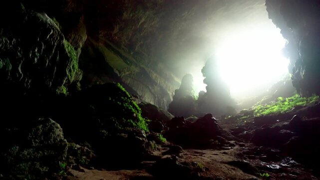 Cinematic view of the Bat Cave (Hang Doi) in Pu Luong Nature Reserve, Vietnam, featuring ancient limestone karst formations and lush green wilderness.