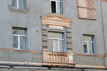 Naklejka premium Weathered building facade during restoration works, horizontal steel support reinforcement beam. Building facade wall under restoration, decorative classical window frame with triangular pediment
