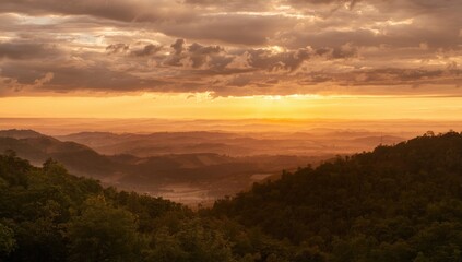 Obraz premium Luminous sunset showering a wide natural landscape with soft clouds on a heated summer afternoon