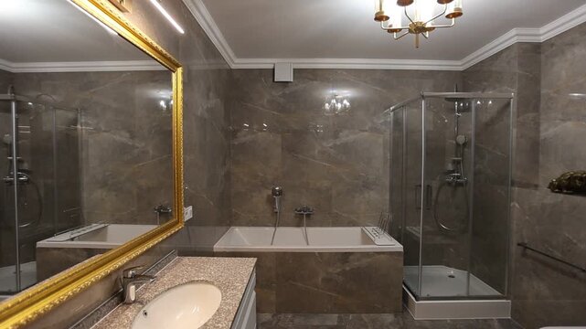 Elegant luxury bathroom interior with mirror, sink, glass shower cabin, bidet, marble tile walls