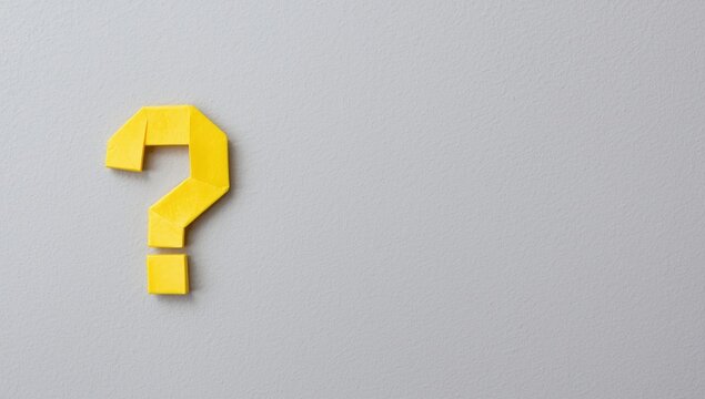 Yellow question mark symbol on a gray wall