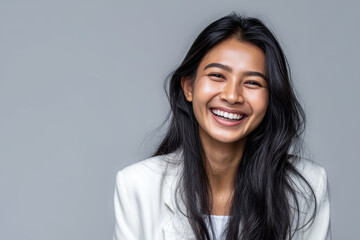 Fototapeta premium Smiling Asian woman in a white blazer creates a clean, modern visual suitable for professional branding, corporate identity, and beauty advertising.