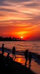Fototapeta premium Silhouettes of People Enjoying Vibrant Sunset at Beach.