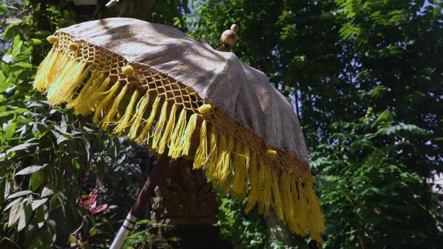 Balinese temple tedung ceremonial umbrella in the sunshine. Balinese Hindusim. 