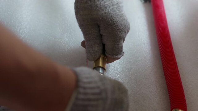 Installing brass fitting into plastic pipe during plumbing installation