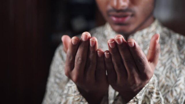Muslim Man offers prayer with open hands in a quiet space