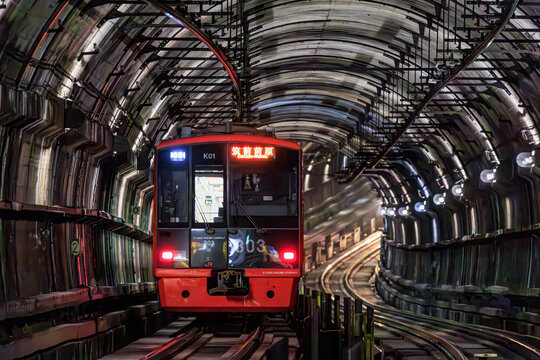 Fukuoka Japan - 2021 06 16: A red JR Kyushu 303 series train bound for Chikuzen-Maebaru emerges from a curved tunnel.
