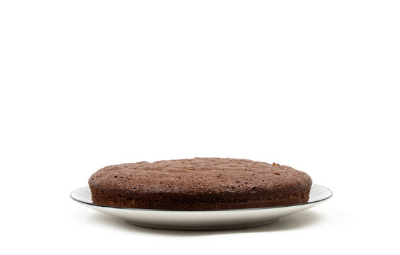 G&acirc;teau au chocolat fait maison aux amandes sur une assiette en c&eacute;ramique, fond blanc isol&eacute; - vu de c&ocirc;t&eacute;