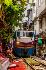 A close up view of a train approaching in train street in Hanoi, Vietnam, in the morning