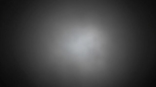A soft white light glows within a dark gray background