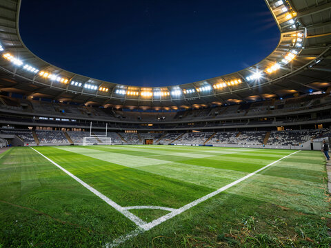 Empty football stadium at night with bright lights