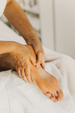 Close up of foot massage therapy session. Female massage therapist's hands.