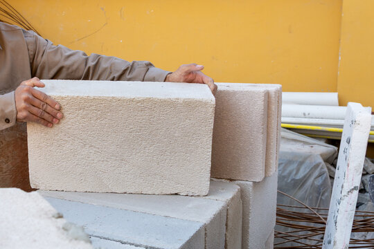 Construction Worker Hands Stacking Autoclaved Aerated Concrete AAC Blocks on Site