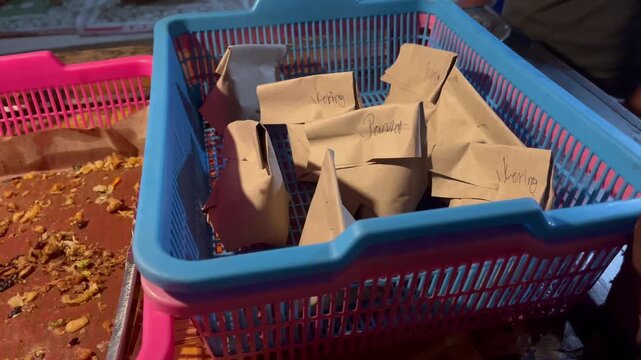 Indonesian traditional nasi kucing wrapped in brown paper inside basket