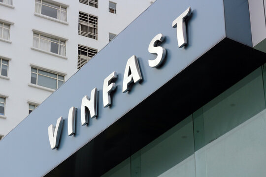 DANANG, VIETNAM - JANUARY 22, 2026: A close-up view of VinFast corporate metallic 3D sign letters on a building facade with windows of an adjacent skyscraper visible.