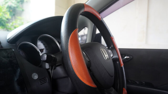Purwokerto, Indonesia - 14 June 2026: Honda steering wheel with two-tone black and brown leather cover inside car cabin, instrument cluster visible.