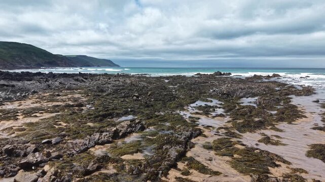 Rocky coast of sand and seaweed in Cornwall