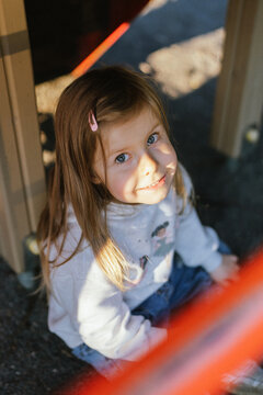 Cute beautiful smiling little girl on the playground for fun, games or recreation. Face and happy with adorable kid outdoor for development, growth or recess in summer.