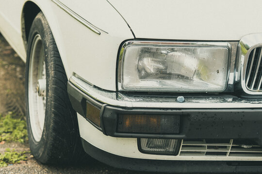 Close Up of Classic Vintage Car Front End with Headlight, Chrome Grille and Bumper Detail