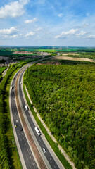 Obraz premium Aerial vertorama of a UK Motorway cutting through woodland countryside
