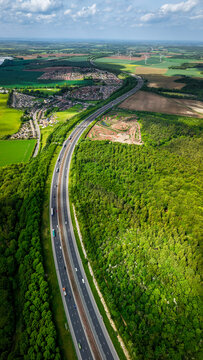 Aerial vertorama of a UK Motorway cutting through woodland countryside