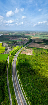 Aerial vertorama of a UK Motorway cutting through woodland countryside
