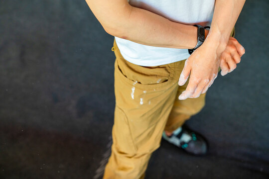 anonymous rock climber with chalk hands at gym 