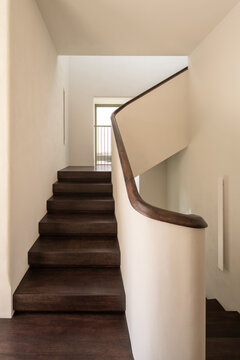 Wooden staircase with sculptural handrail