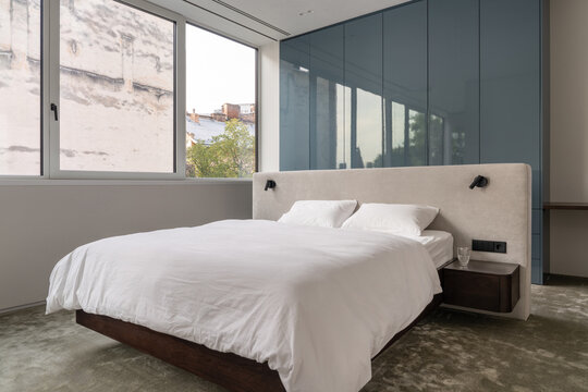 Bright bedroom with large window and soft textiles