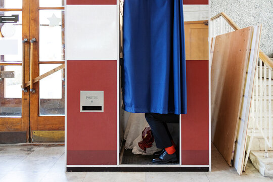 Bride and groom in a photo booth in a public place.