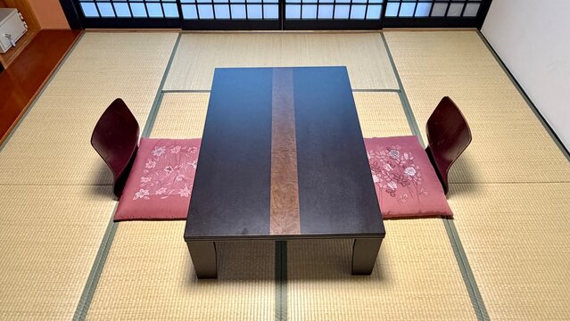 和室の中央に整えられた座卓と刺繍入り座布団のクローズアップ