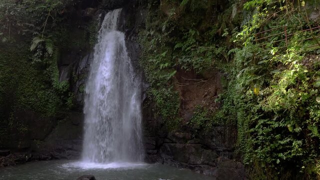 Ulu Petanu Waterfall flowing in the jungle of Bali, Ubud. Tropical cascade of water in the forest. 