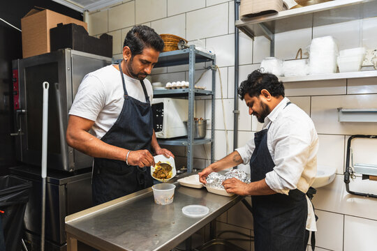 Indian chefs preparing delivery orders in kitchen