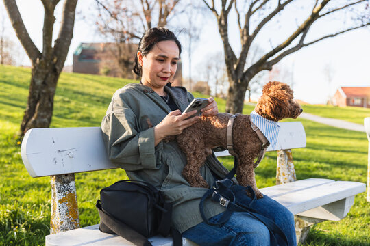 Asian woman using smartphone with pet dog