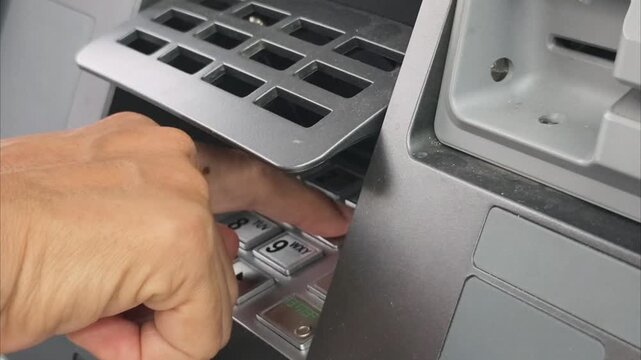 4k video - Close-up of a woman's hand entering a secret PIN code on an ATM machine keypad.