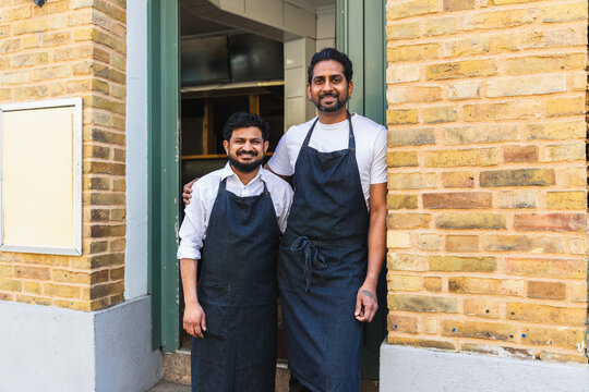 Smiling Indian restaurant owners at entrance