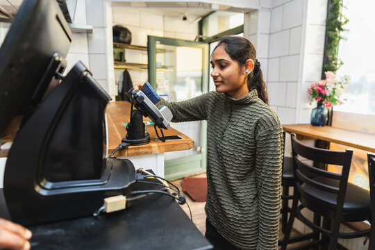 Indian woman paying with card at counter