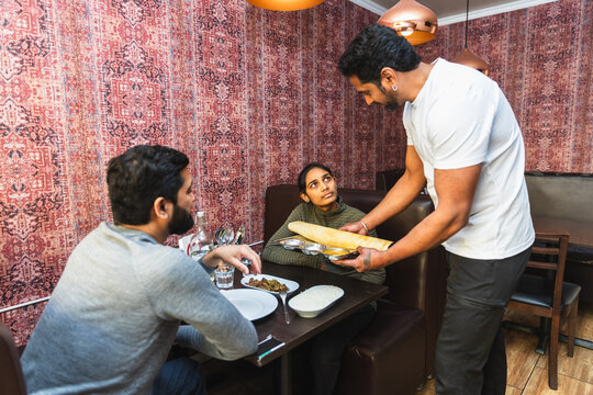 Server placing traditional dosa for diners