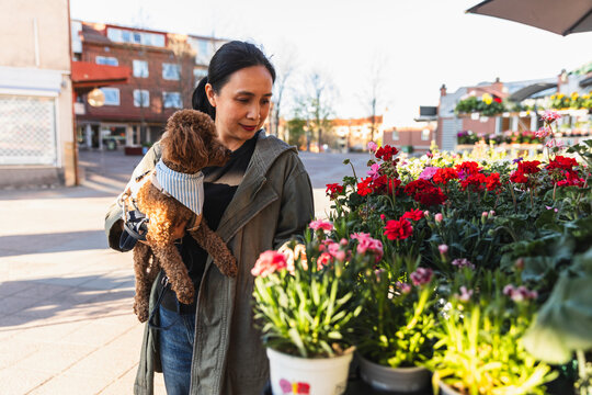 Asian woman at flower shop with poodle