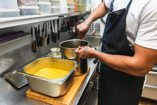 Close up of chef pouring yellow lentil curry