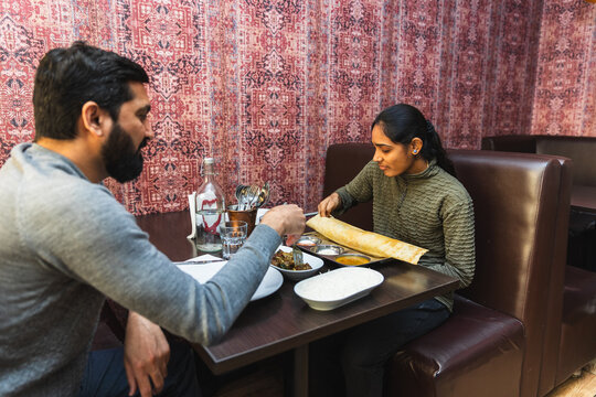 Indian woman tearing a piece of dosa