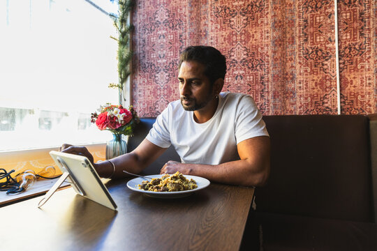 Man using tablet while eating staff meal