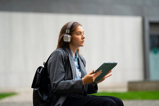 Woman using tablet and listening to music