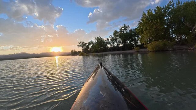 Immersive POV from a kayak - paddling on Boedecker Reservoir in Loveland, Colorado, with sunset over Rocky Mountains