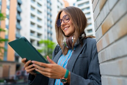 A woman stands outside a building in a city