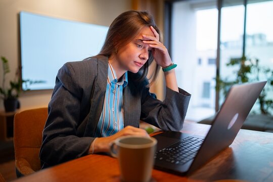 Stressed businesswoman working on laptop