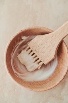 Wooden hair colour brush in a wooden bowl