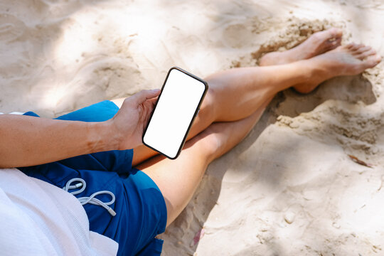 Man holding a phone with on the beach