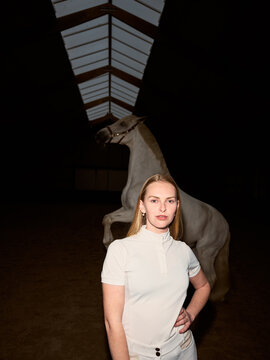 Woman Stands With Horse in Indoor Riding Arena